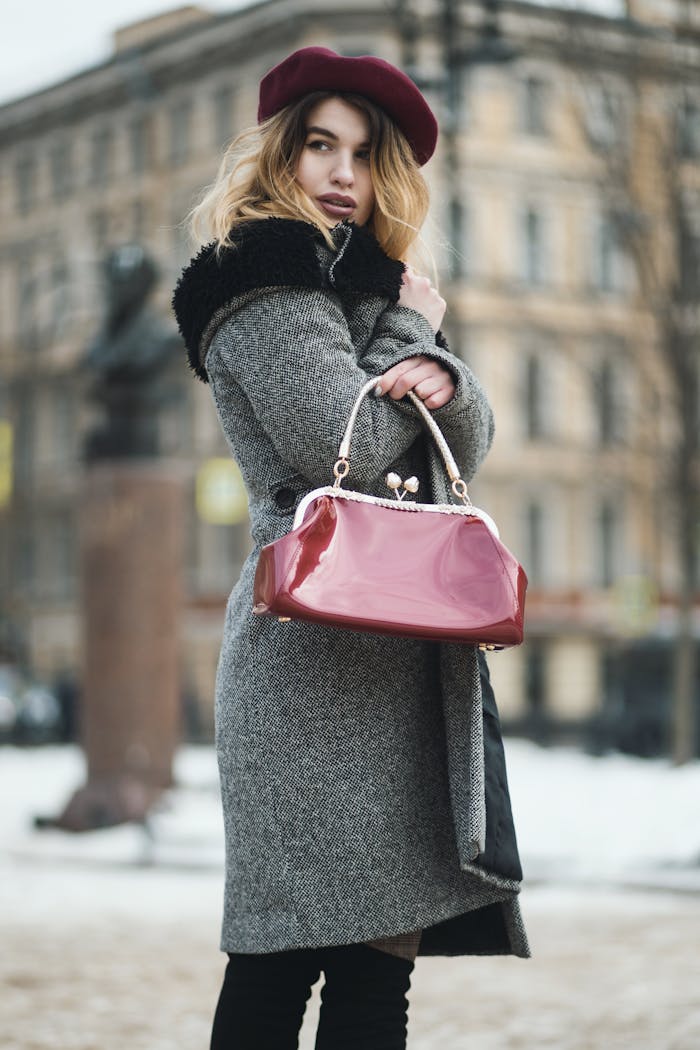 services-03 Stylish woman in winter coat and beret holding handbag outdoors.